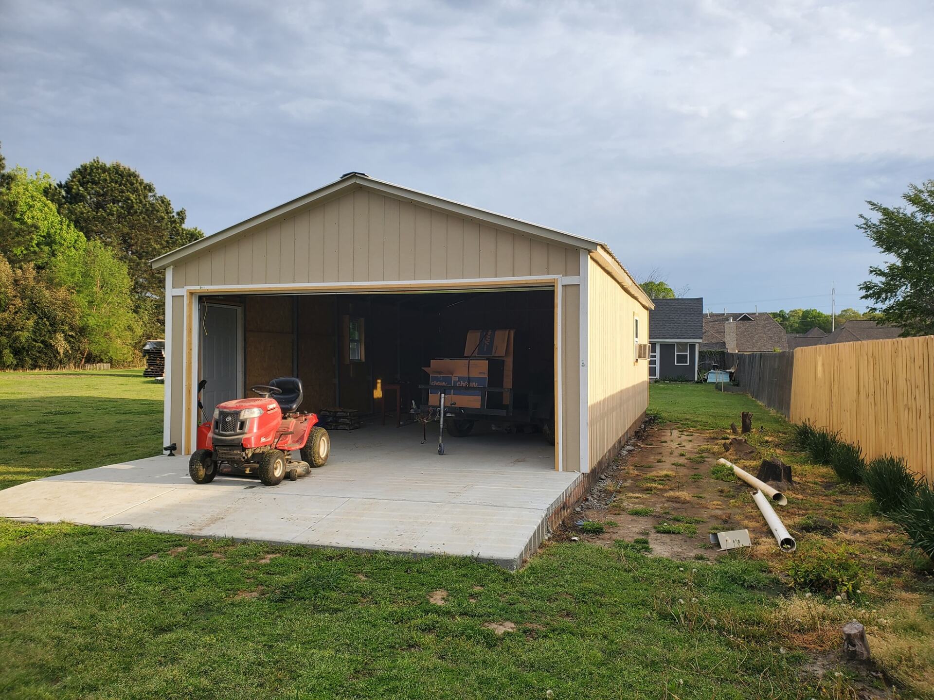 A lawn mower is parked inside of a garage.