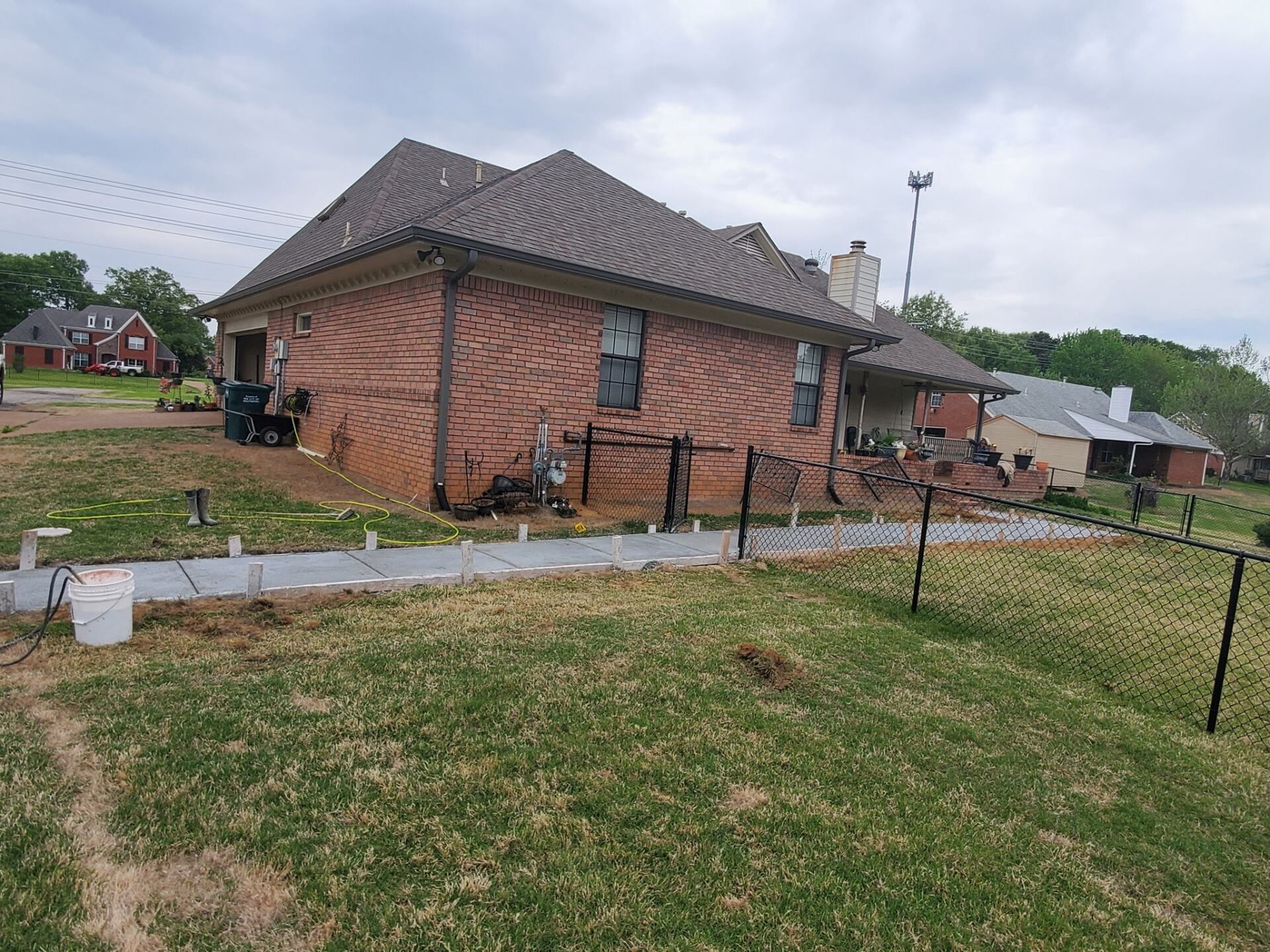 A brick house is sitting on top of a lush green field.