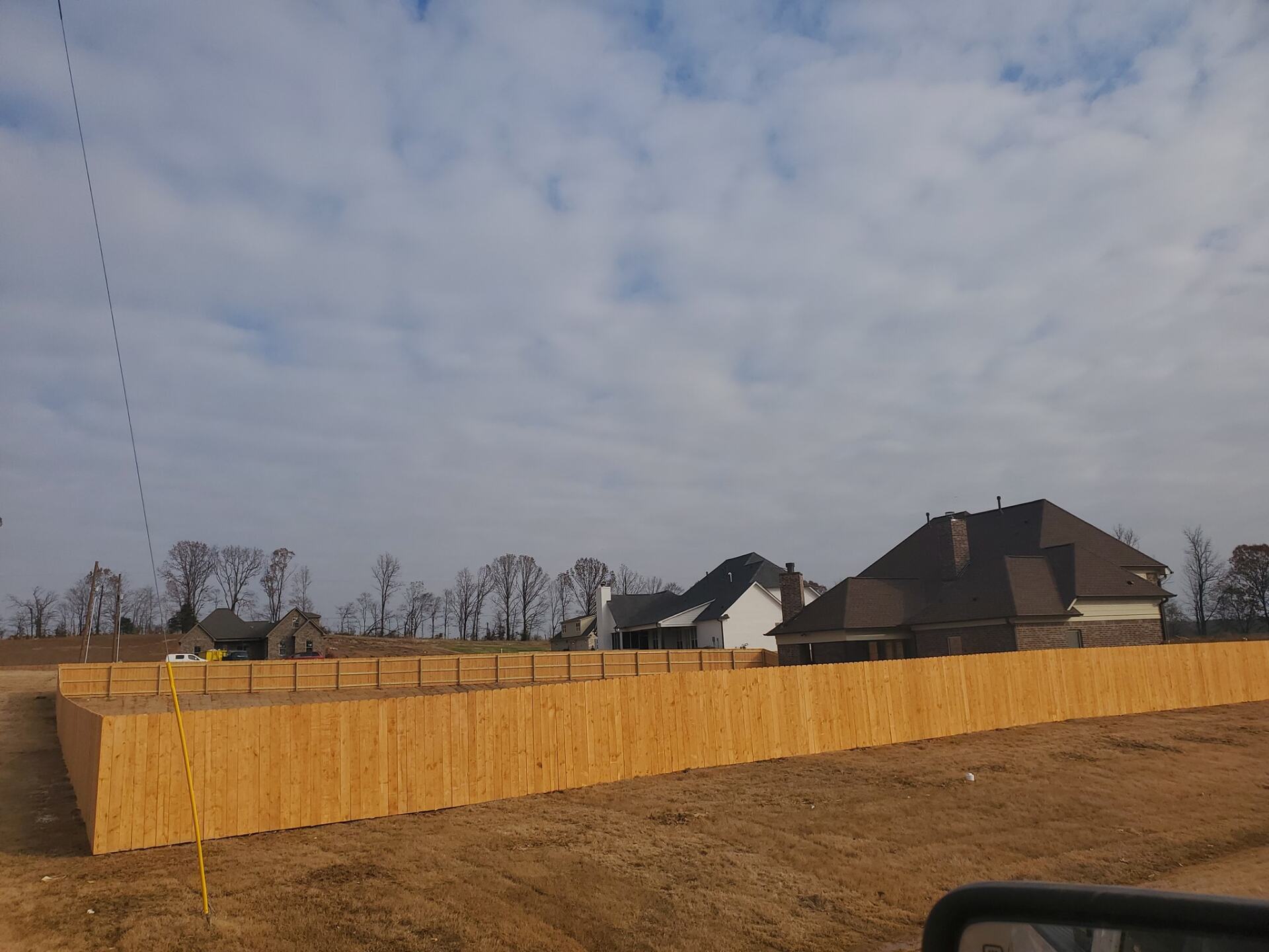 A wooden fence with a house in the background
