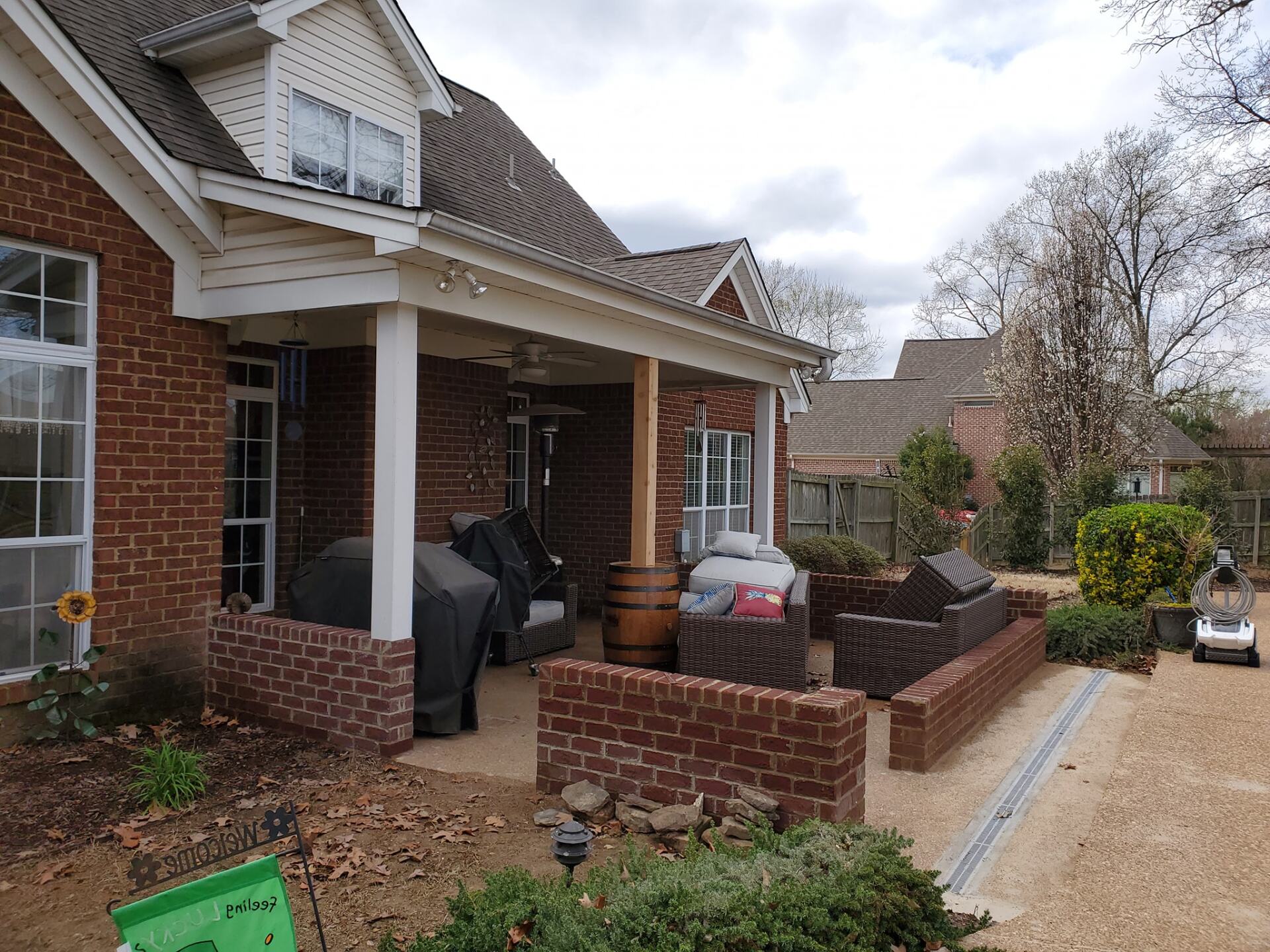 A brick house with a porch and a grill