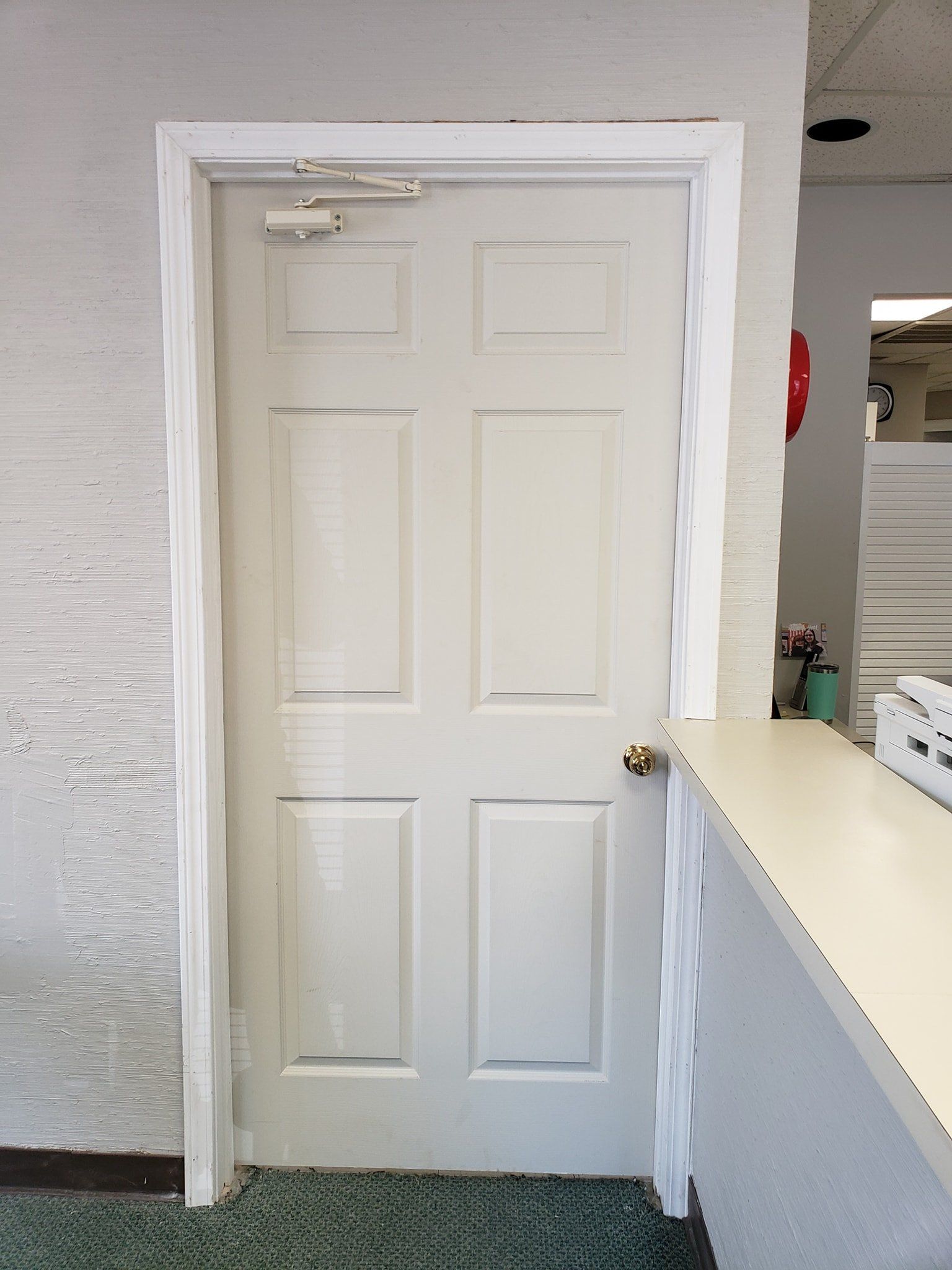 A white door is open in a room next to a counter.