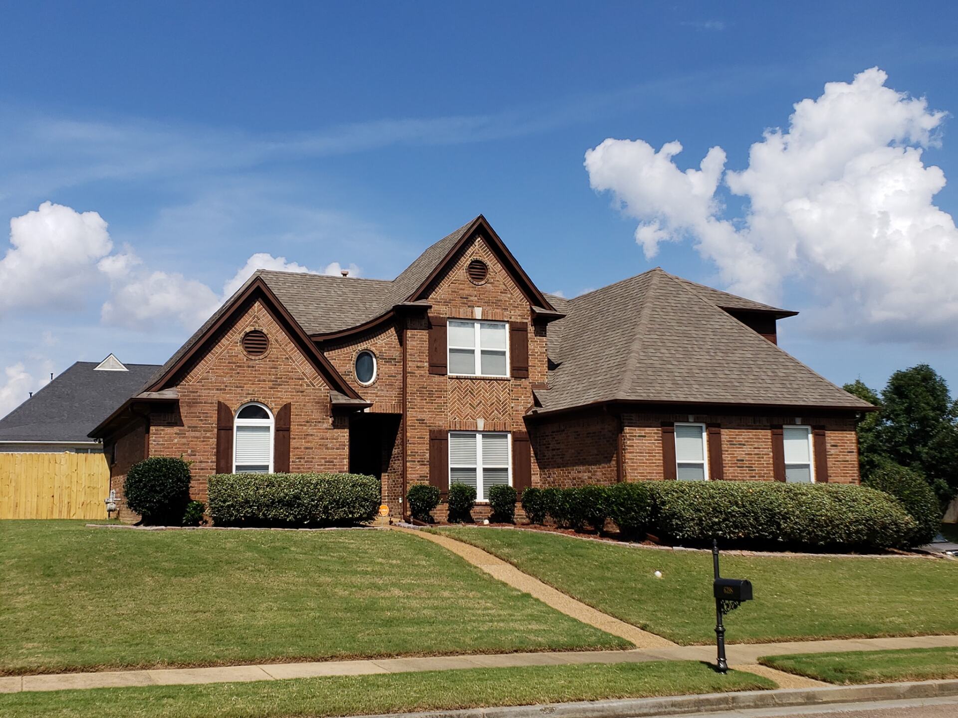 A large brick house with a mailbox in front of it
