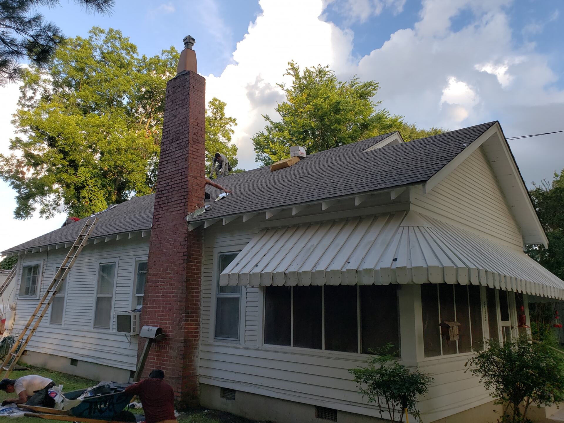 A man is working on the roof of a house.
