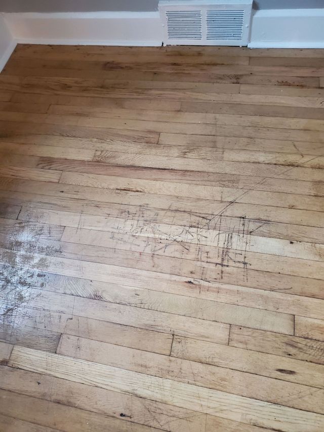 A modern living room with a brick wall, wood ceiling, wood-burning stove, bright teal sofas, and a red area rug.