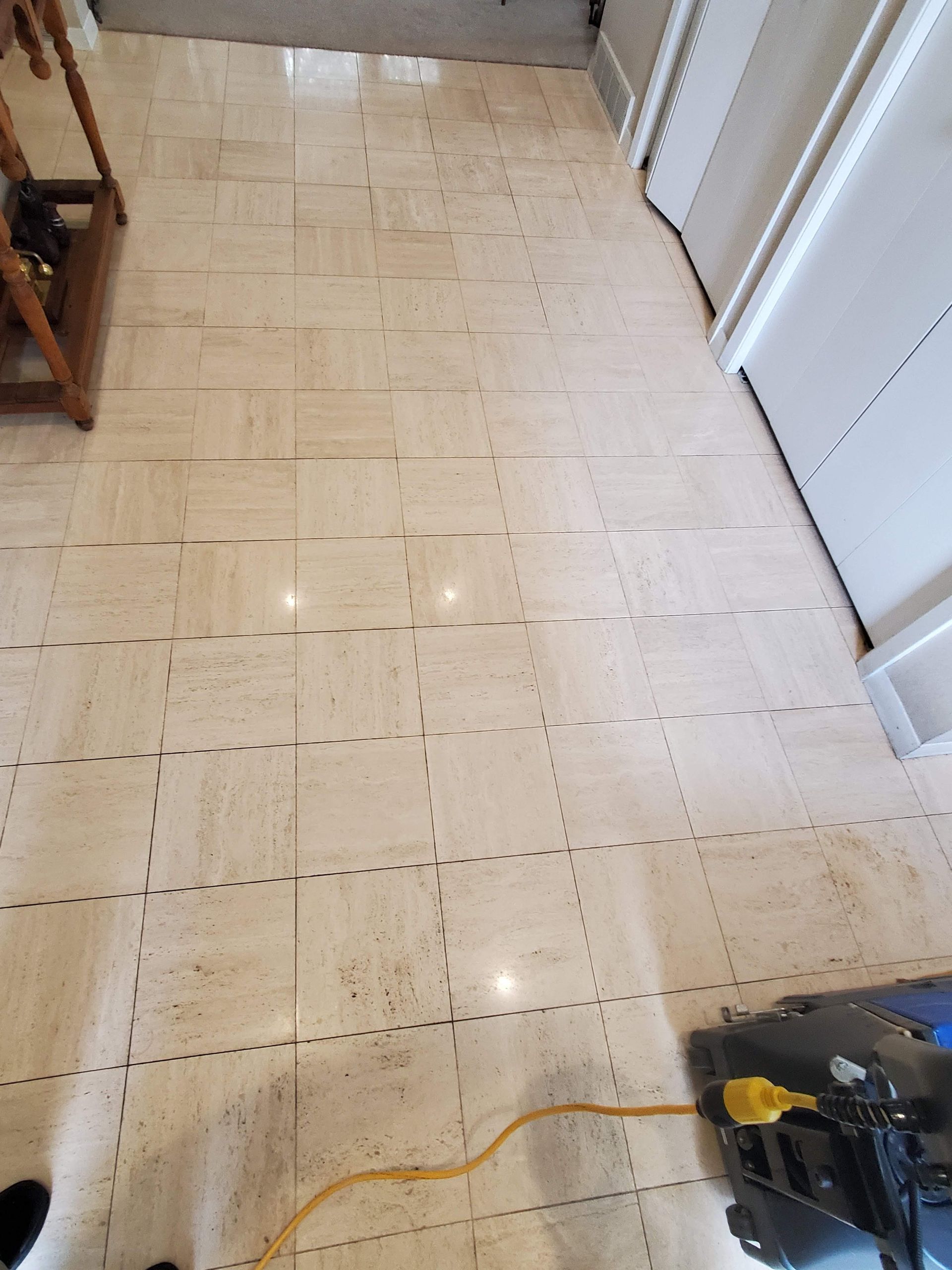 Hallway with light tile floor, white doors, and a power tool cord near the bottom right.