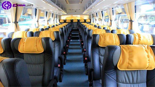 The inside of a bus with yellow seats and black seats.