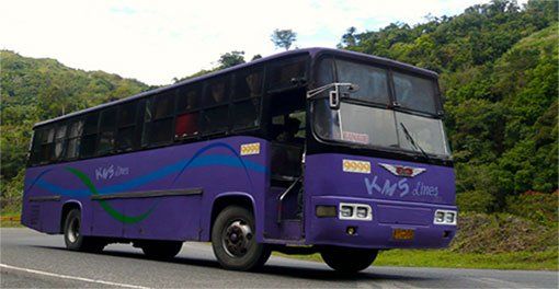 A purple bus with the word kms on it