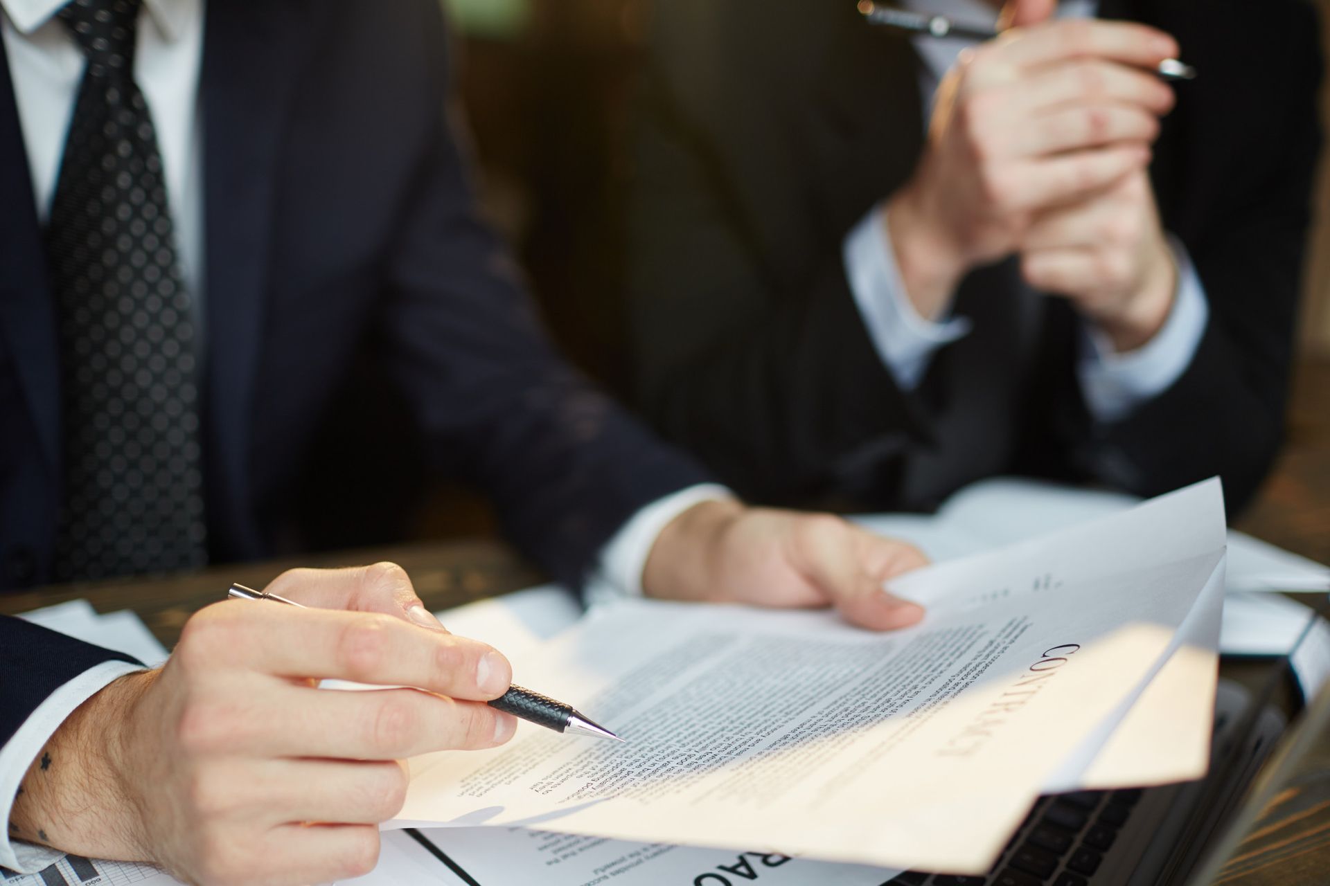 A man is writing on a piece of paper with a pen.
