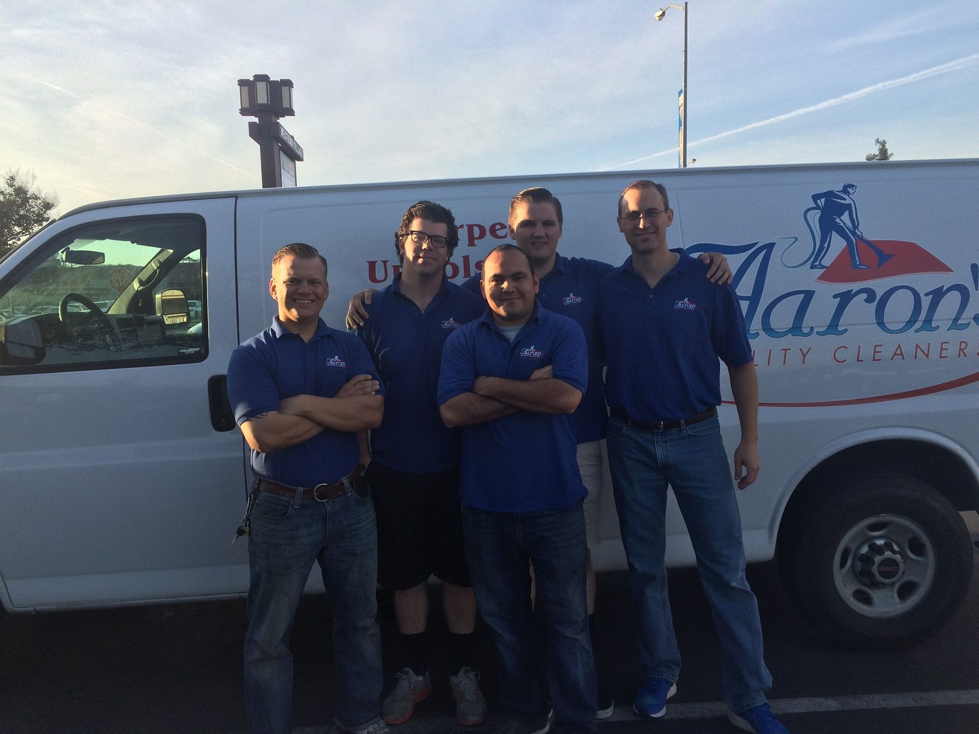 Aaron's team standing in front of a white van with logo