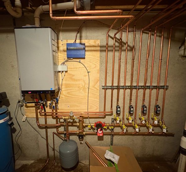 A white air conditioner is mounted on the side of a building.