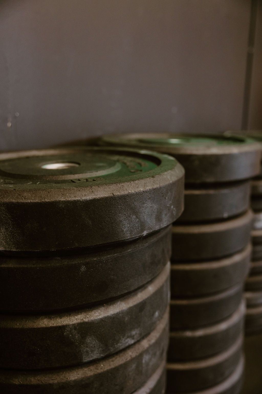 A close up of a stack of weight plates in a gym.