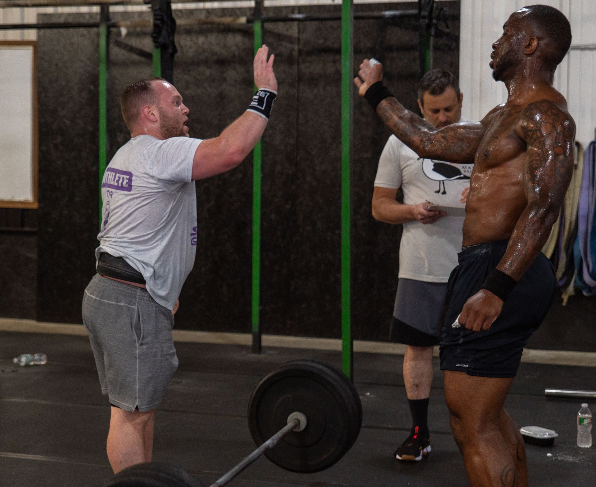 A man giving another man a high five in a gym