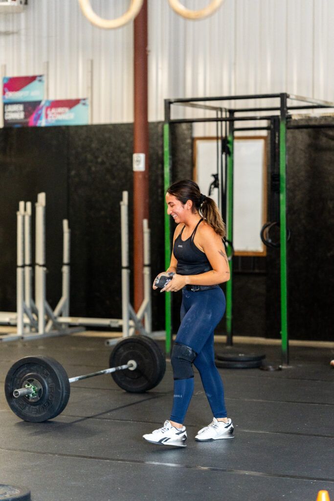 A woman is lifting a barbell in a gym