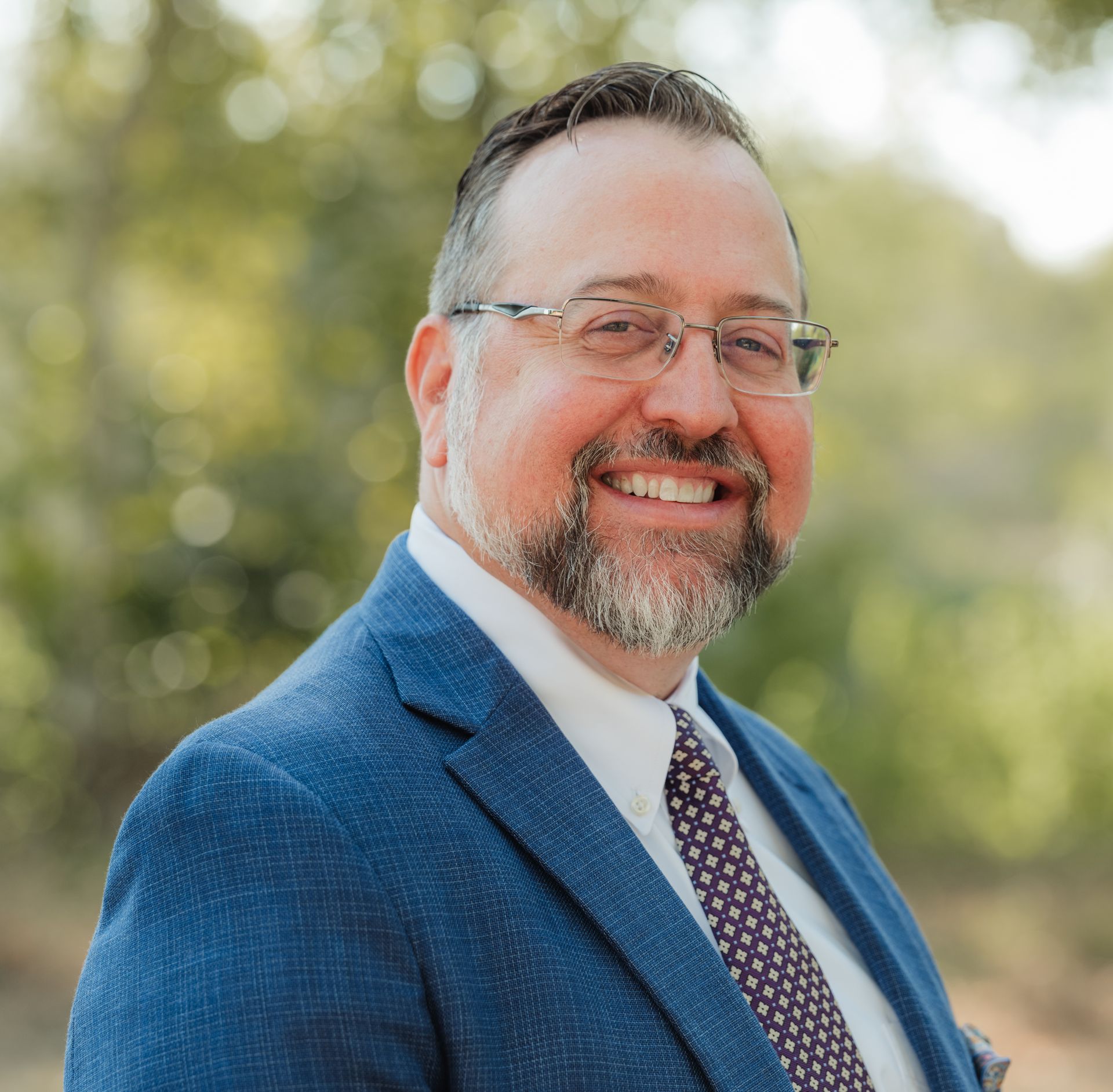 A man in a suit and tie is smiling for the camera.