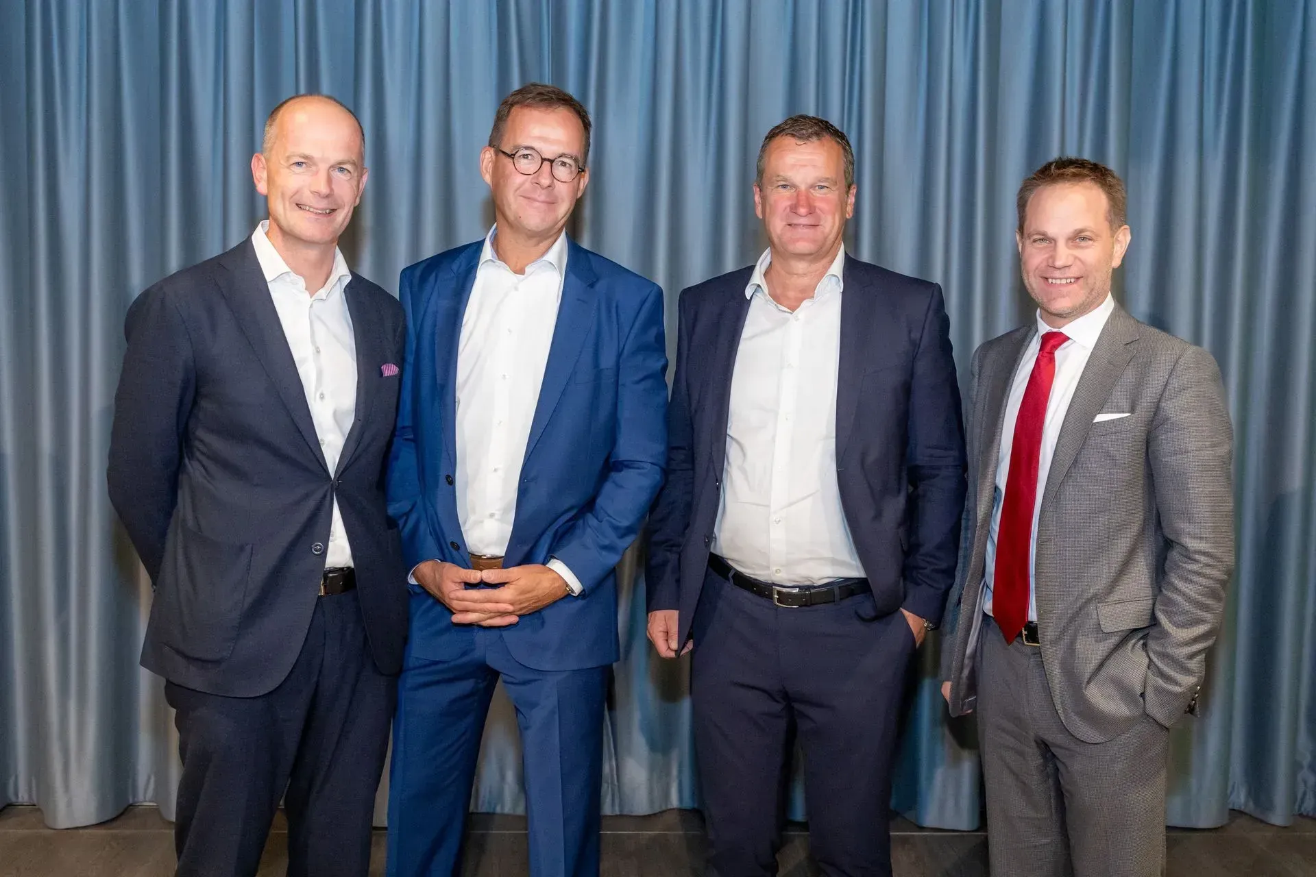 Eine Gruppe von Männern in Anzug und Krawatte posiert für ein Foto.