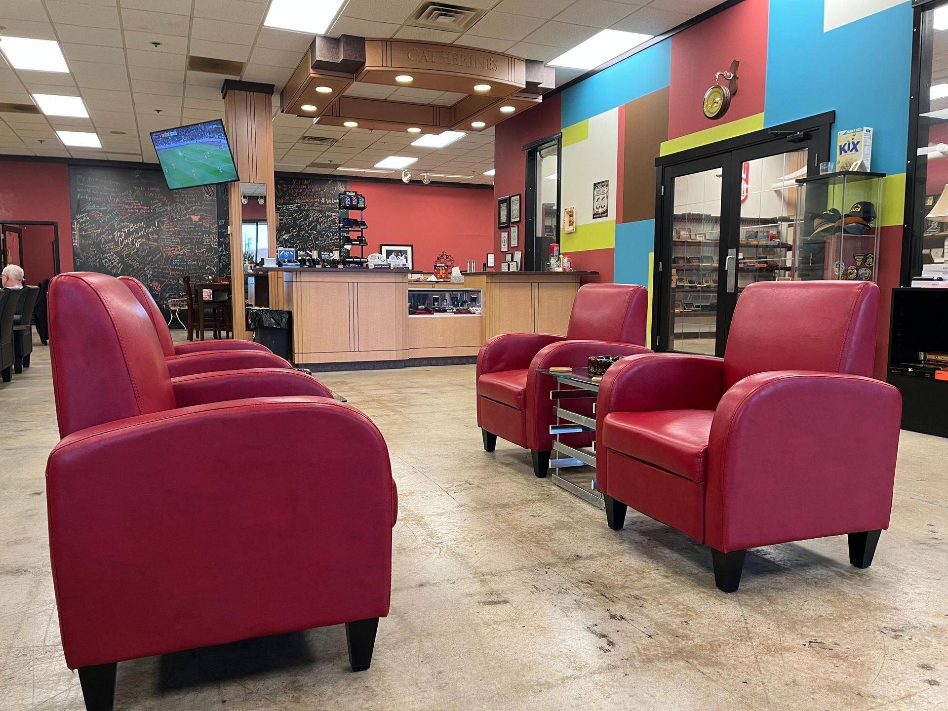 A row of red chairs are sitting in a waiting room.