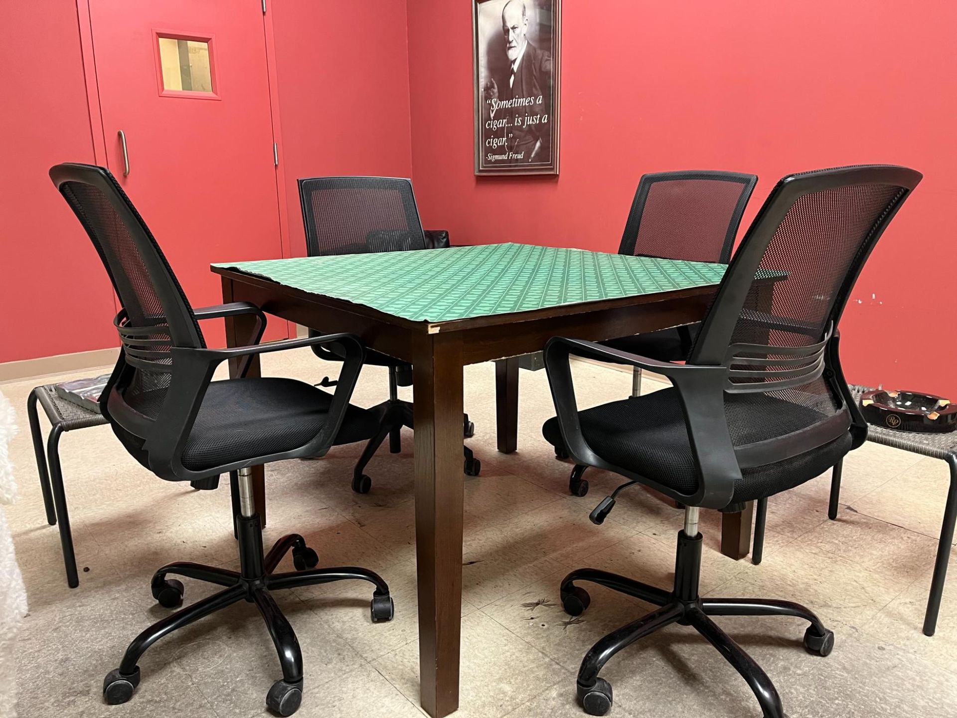 A room with a table and chairs and a picture on the wall.