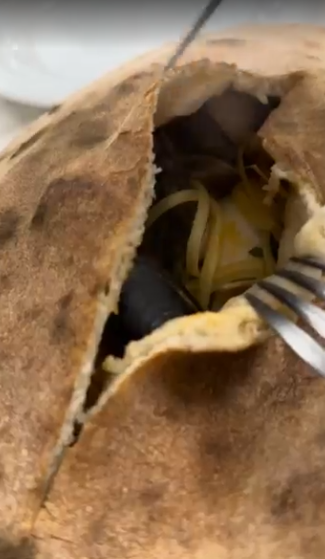 Primo piano di un pasticcino rotto che rivela una forchetta e un ripieno giallo all'interno.