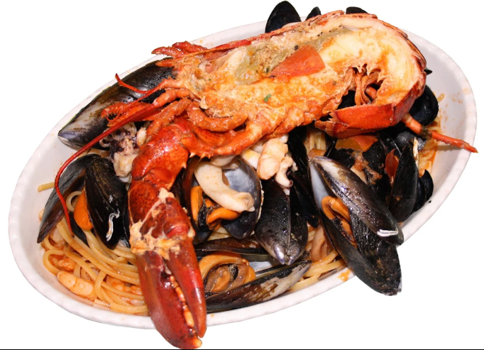 Pasta ai frutti di mare condita con astice, cozze e granchio su un piatto bianco.