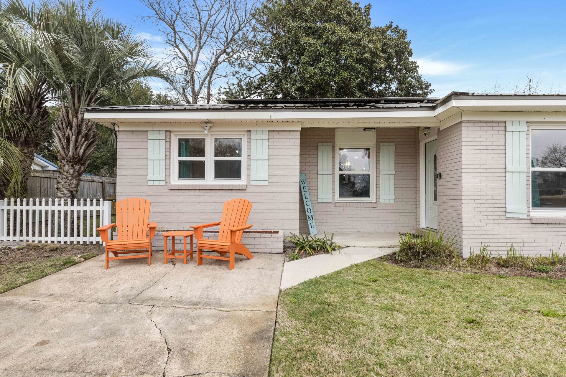 A house with two orange chairs and a table in front of it.