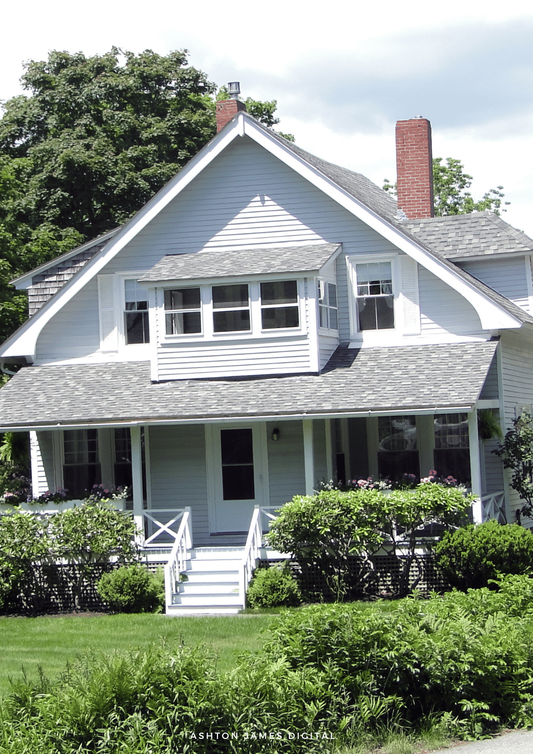 Yellow house with dark brown trim and windows, under overcast sky.