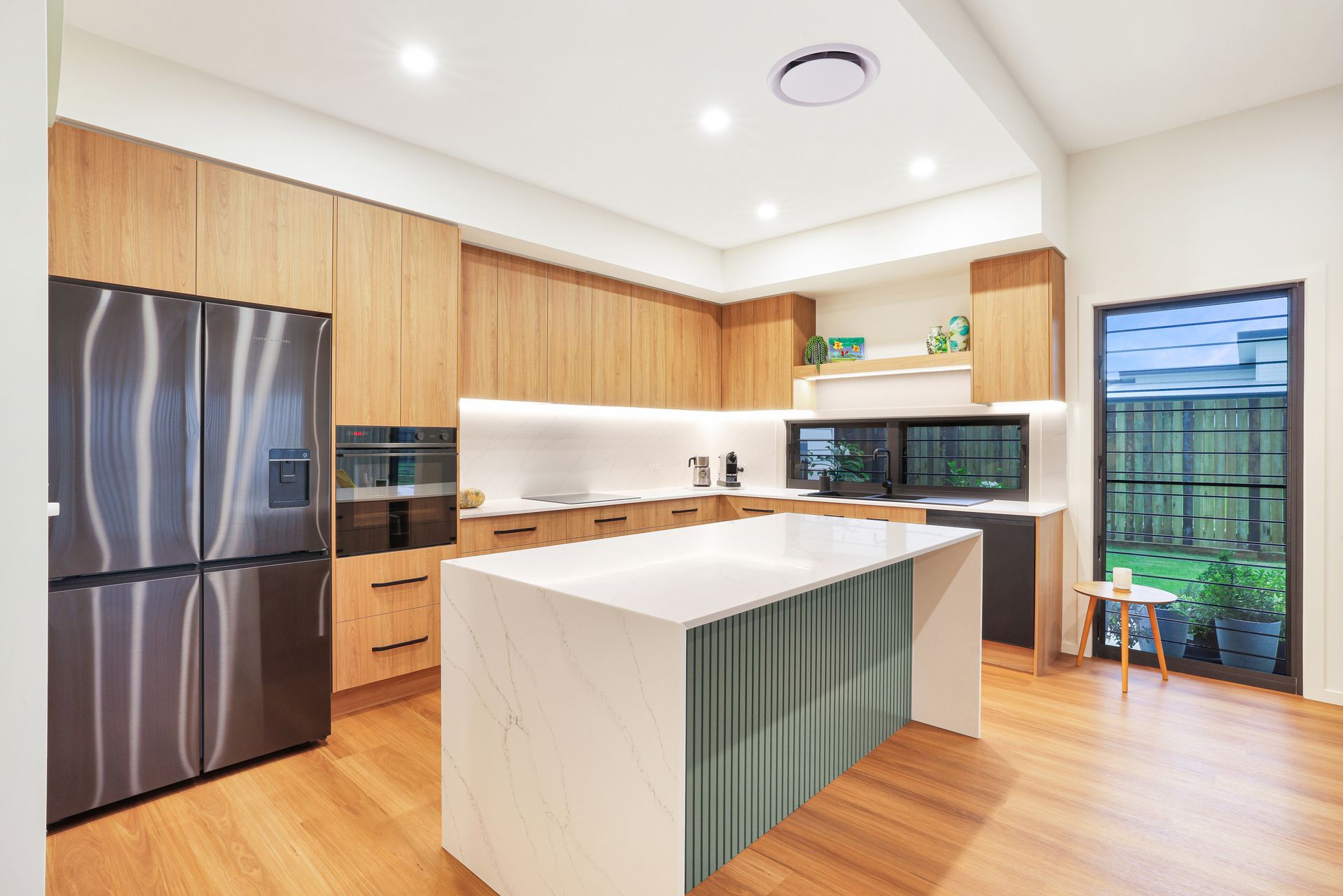 Modern Kitchen With Stainless Steel Fridge, and Sliding Glass Door to a Patio — Master Cabinets Bundaberg in Kensington, QLD