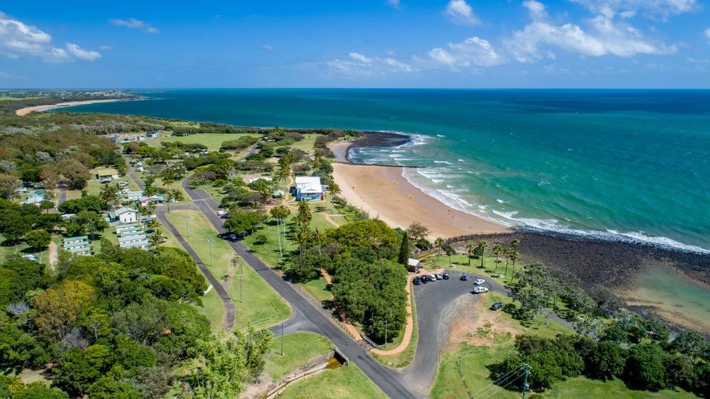 An Aerial View Of A Beach With A Road Leading To It — Master Cabinets Bundaberg in Burnett Heads, QLD