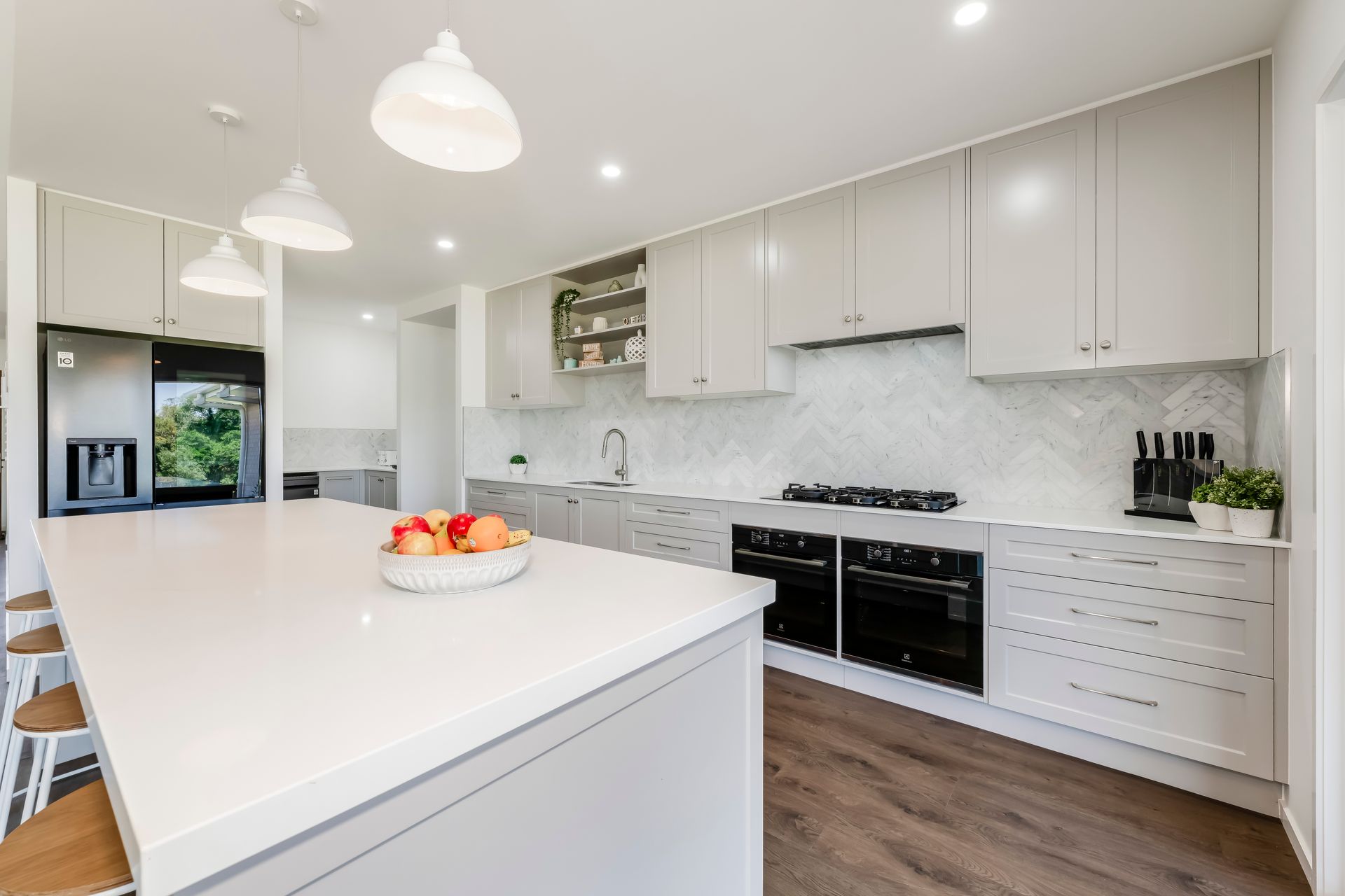 Modern Kitchen With White Cabinets, Island, and Stainless Steel Appliances — Master Cabinets Bundaberg in Kensington, QLD