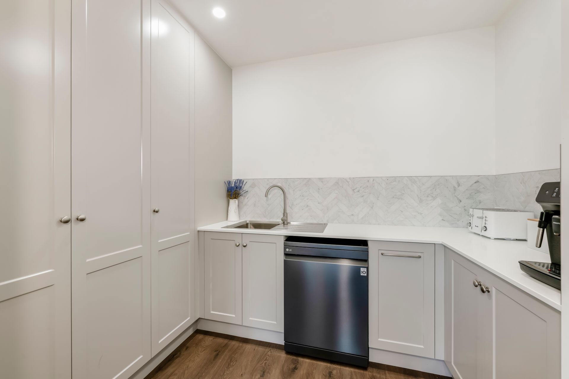 A Kitchen With White Cabinets And A Sink — Master Cabinets Bundaberg in Kensington, QLD