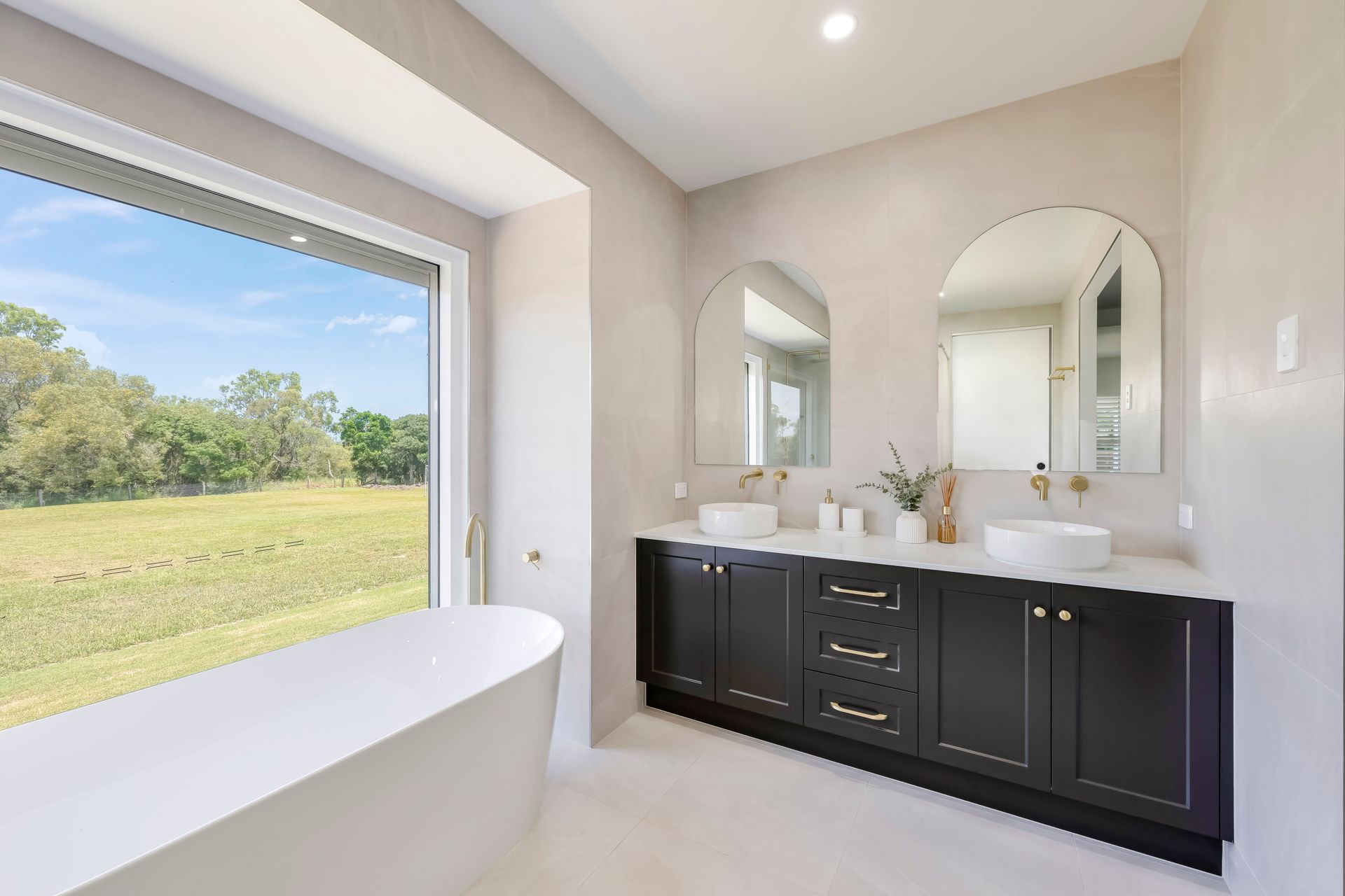 Modern Bathroom With Black Vanity, and a Large Window Overlooking a Field — Master Cabinets Bundaberg in Kensington, QLD