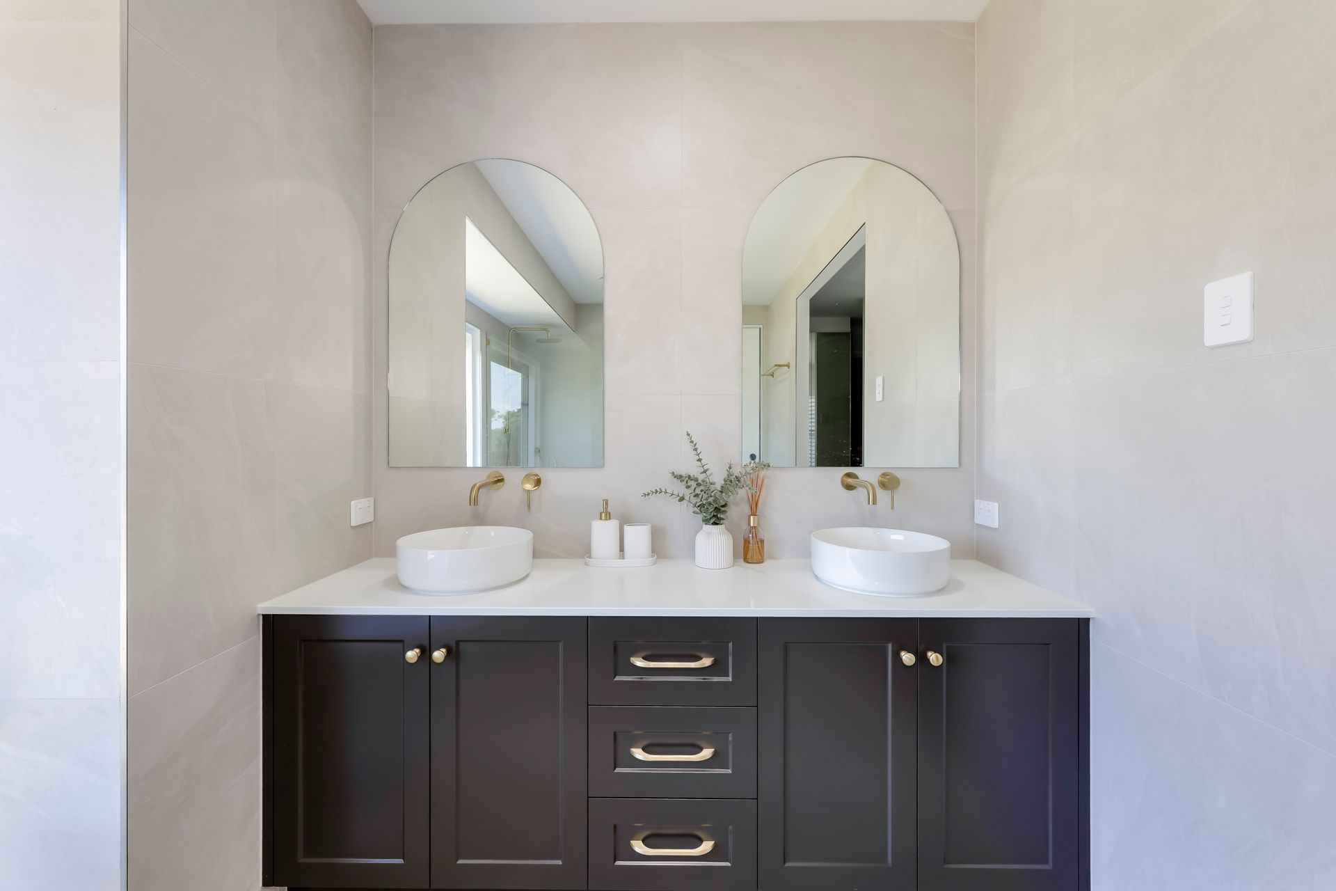 Modern bathroom with a double sink vanity, large mirror, and black fixtures.