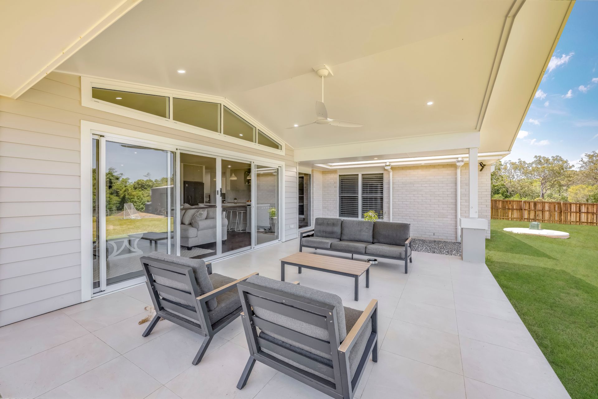 Covered Patio With Outdoor Furniture Overlooking a Green Lawn and Trees — Master Cabinets Bundaberg in Kensington, QLD