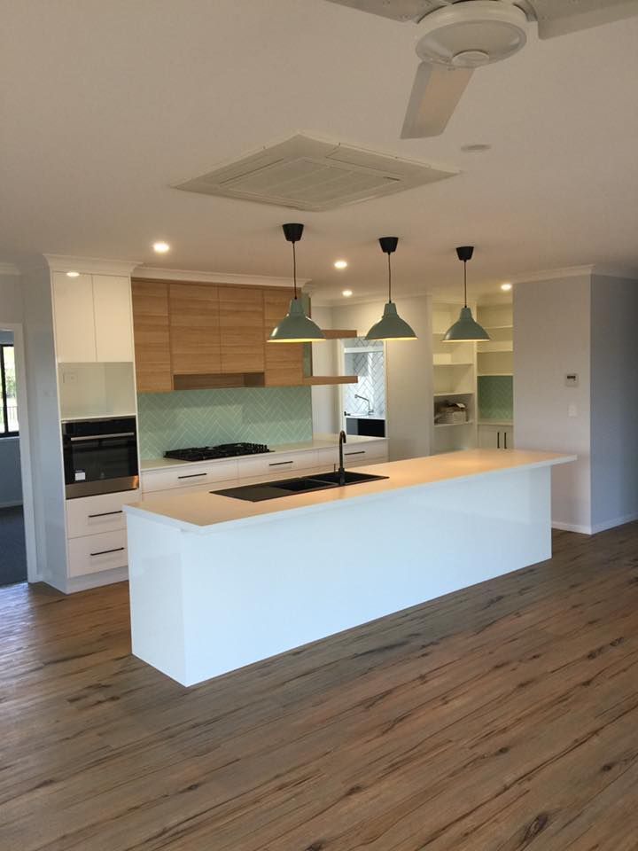 A Kitchen With A Large Island And A Ceiling Fan — Master Cabinets Bundaberg in Burrum Heads, QLD