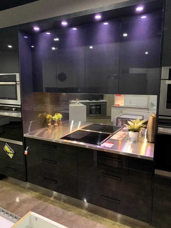 A Kitchen With Black Cabinets And Stainless Steel Counter Tops — Master Cabinets Bundaberg in Burnett Heads, QLD