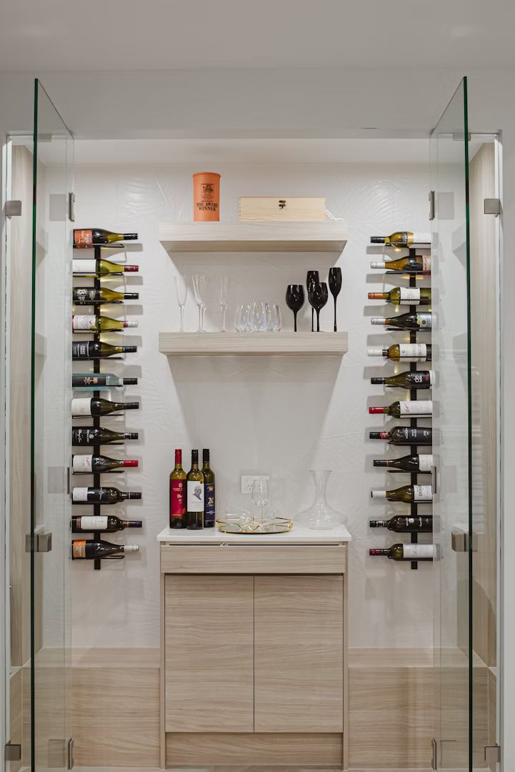 Wine display case with glass doors, wine bottles, glasses, and a wooden cabinet.