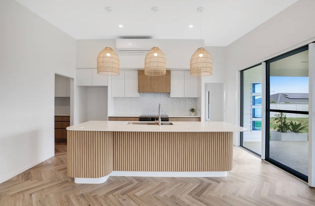 Modern Kitchen With Light Wood Island and Cabinets — Master Cabinets Bundaberg in Kensington, QLD