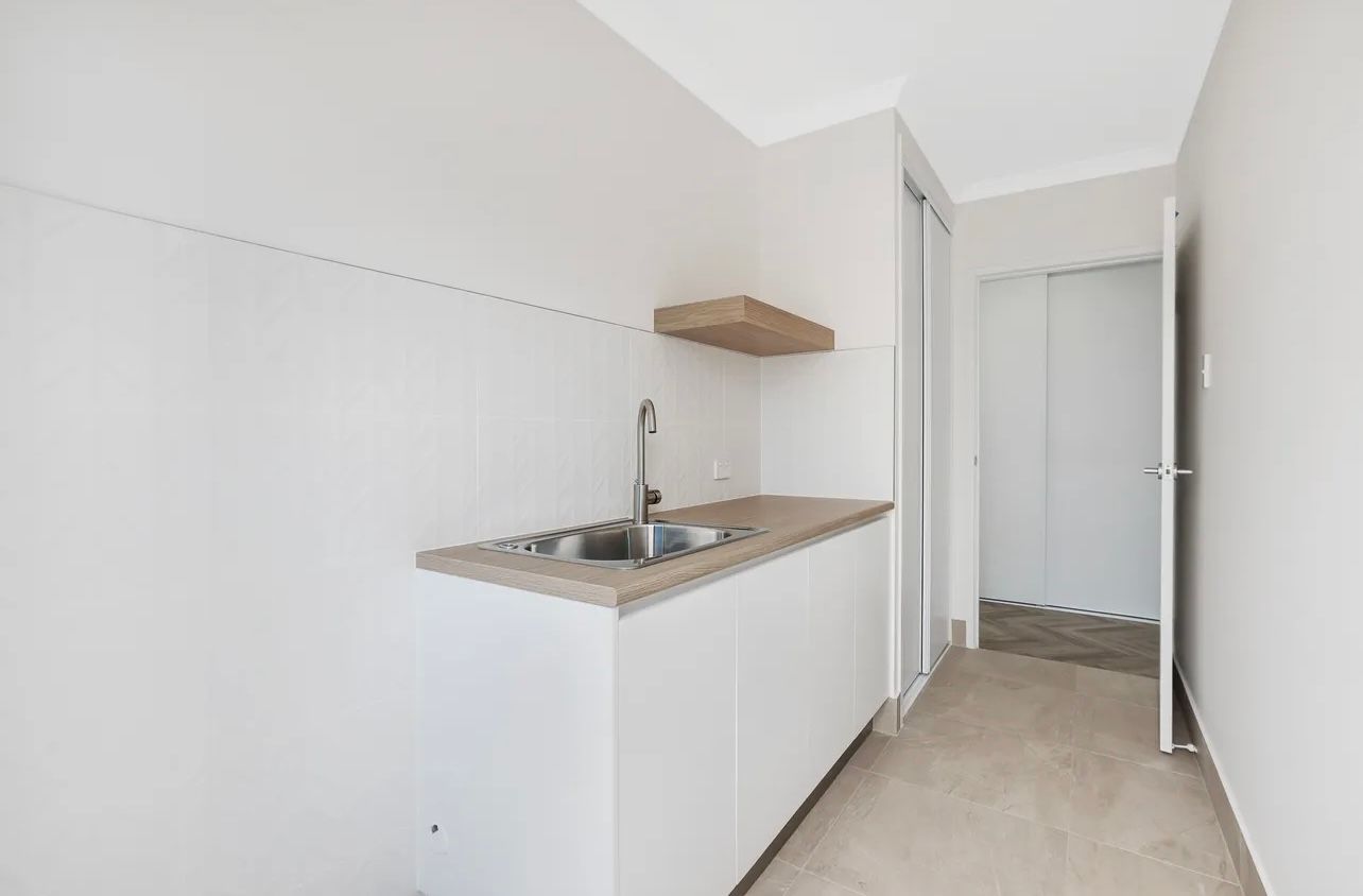 A Kitchen With Gray Cabinets, A Sink, And A Refrigerator — Master Cabinets Bundaberg in Kensington, QLD