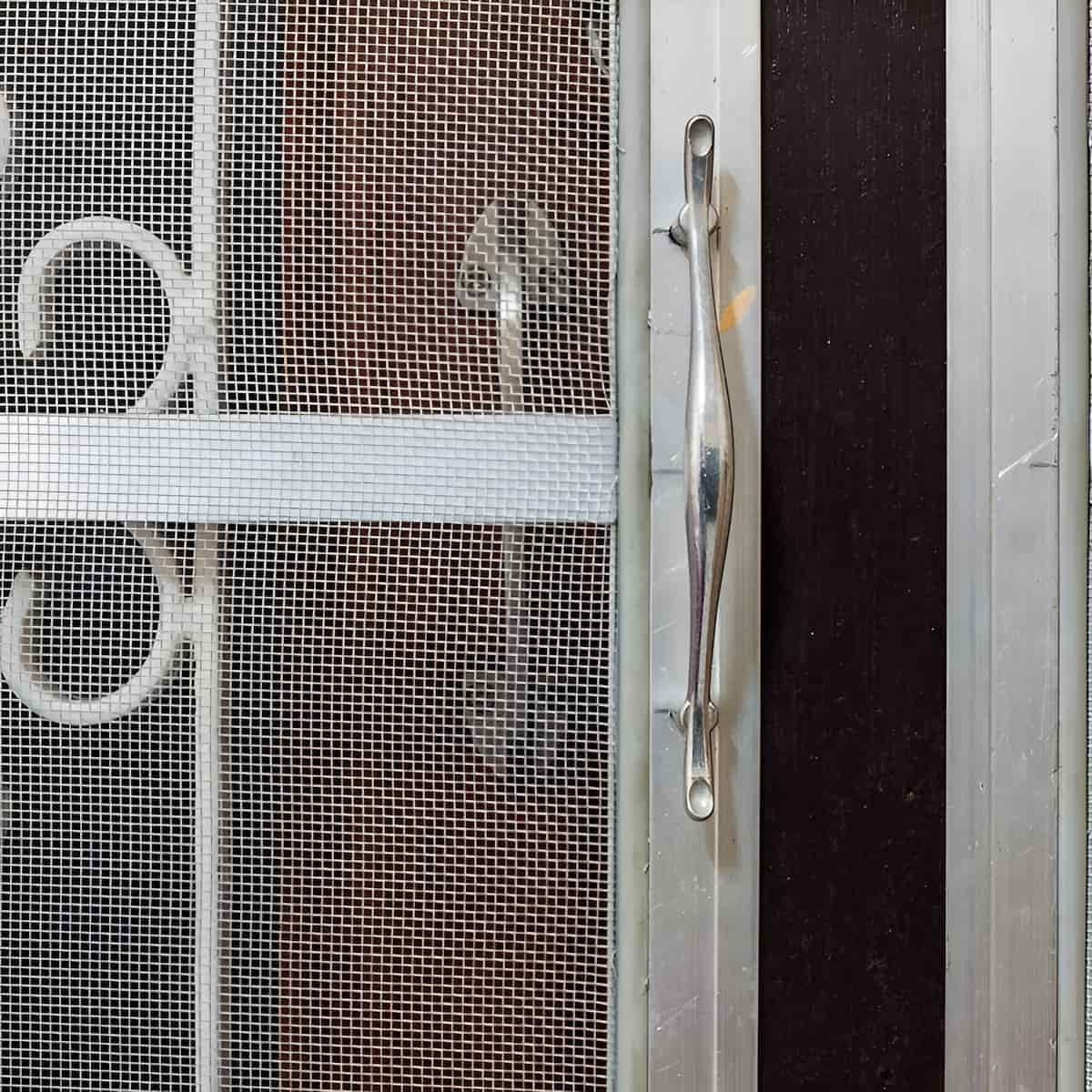 Screen Door With Ornate Metalwork, Silver Handle, And Mesh Screen — Master Cabinets Bundaberg in Redridge, QLD