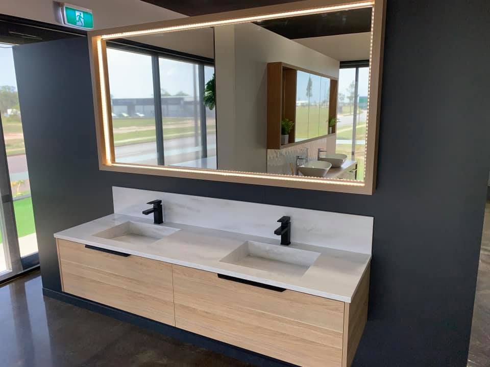 Modern bathroom with a double sink vanity, large mirror, and black fixtures.