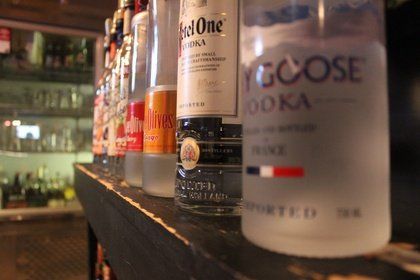 A bottle of goose vodka sits on a bar