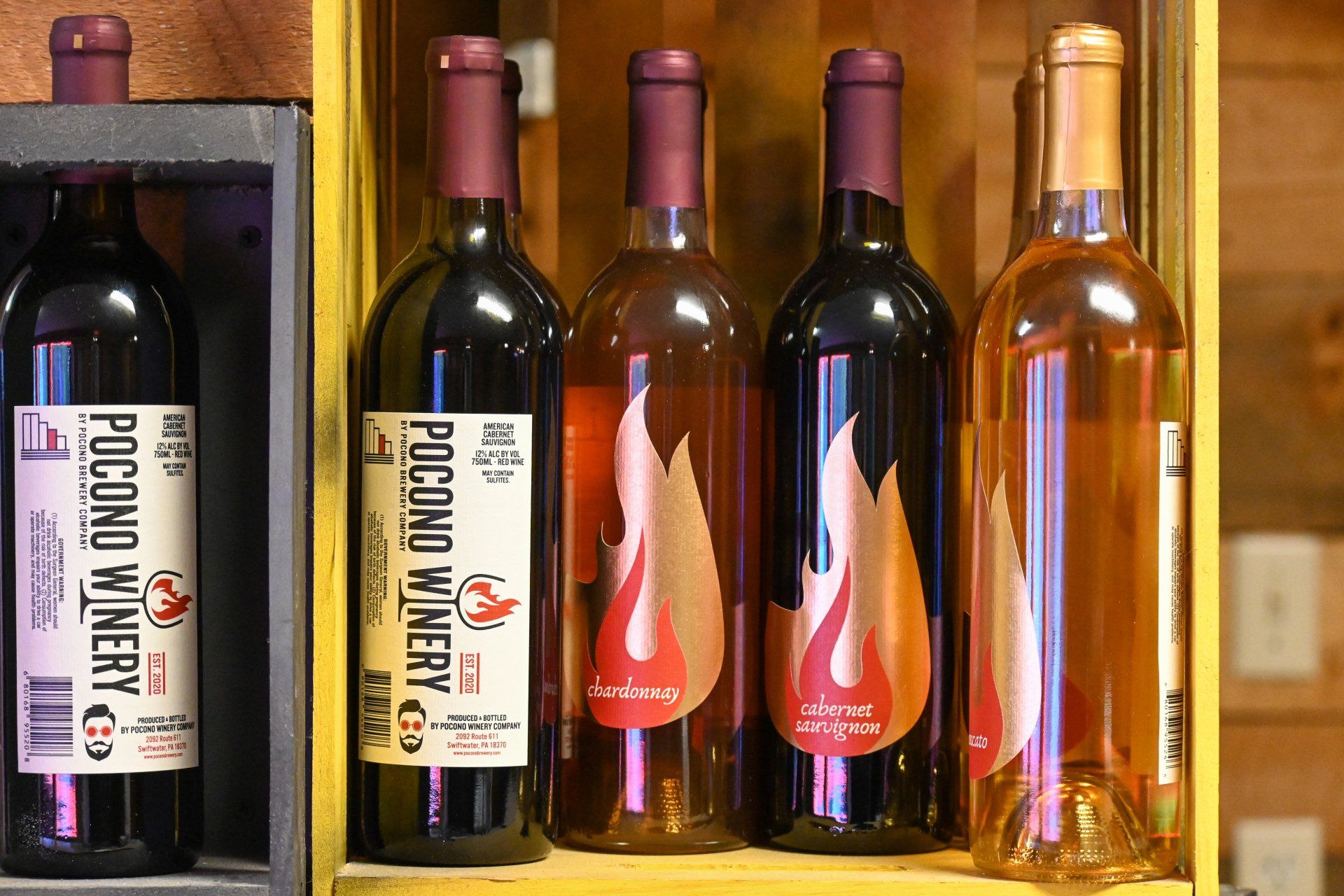 Four bottles of pocono winery wine are on a shelf