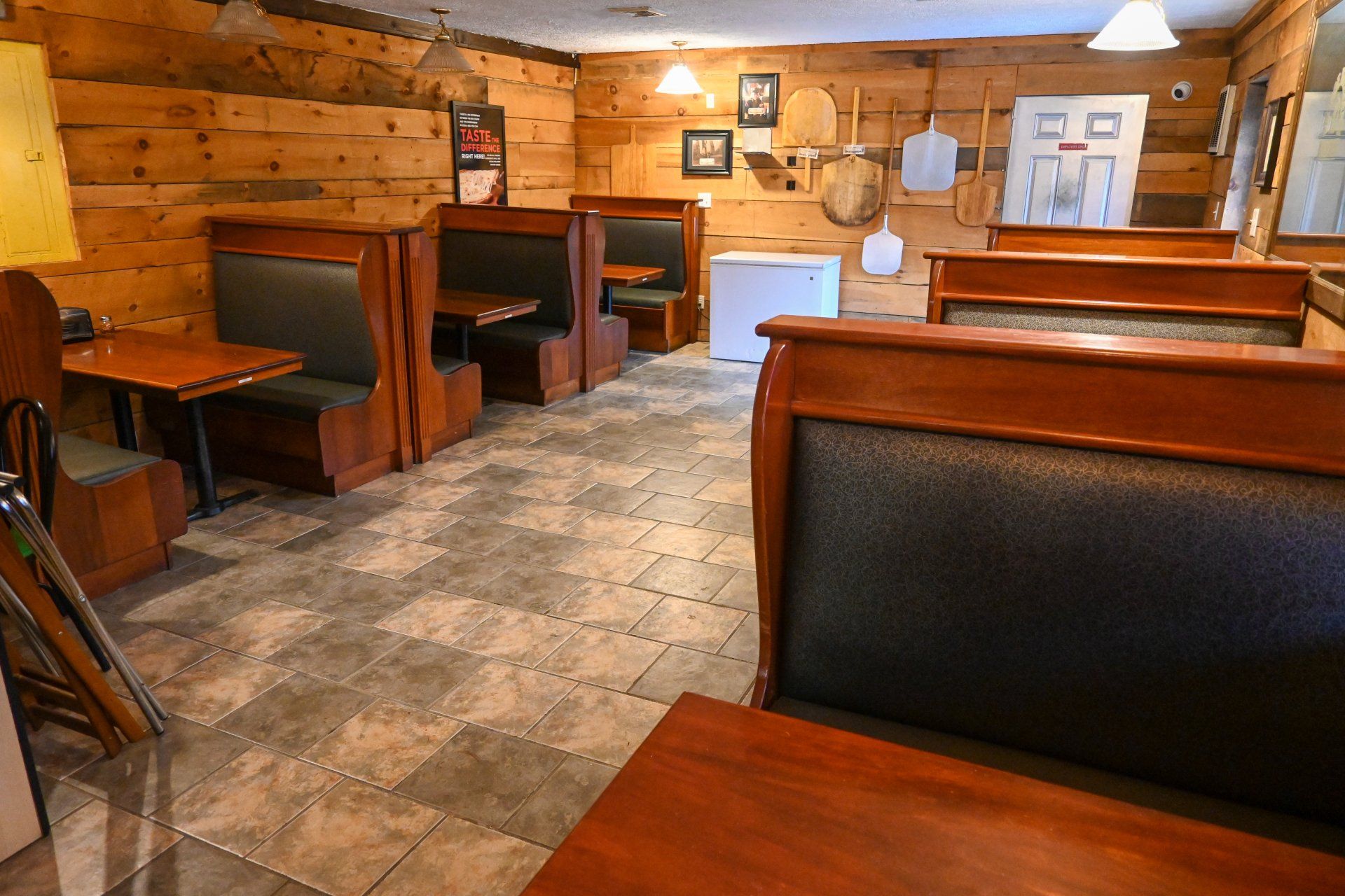 A restaurant with wooden tables and benches and a wooden wall