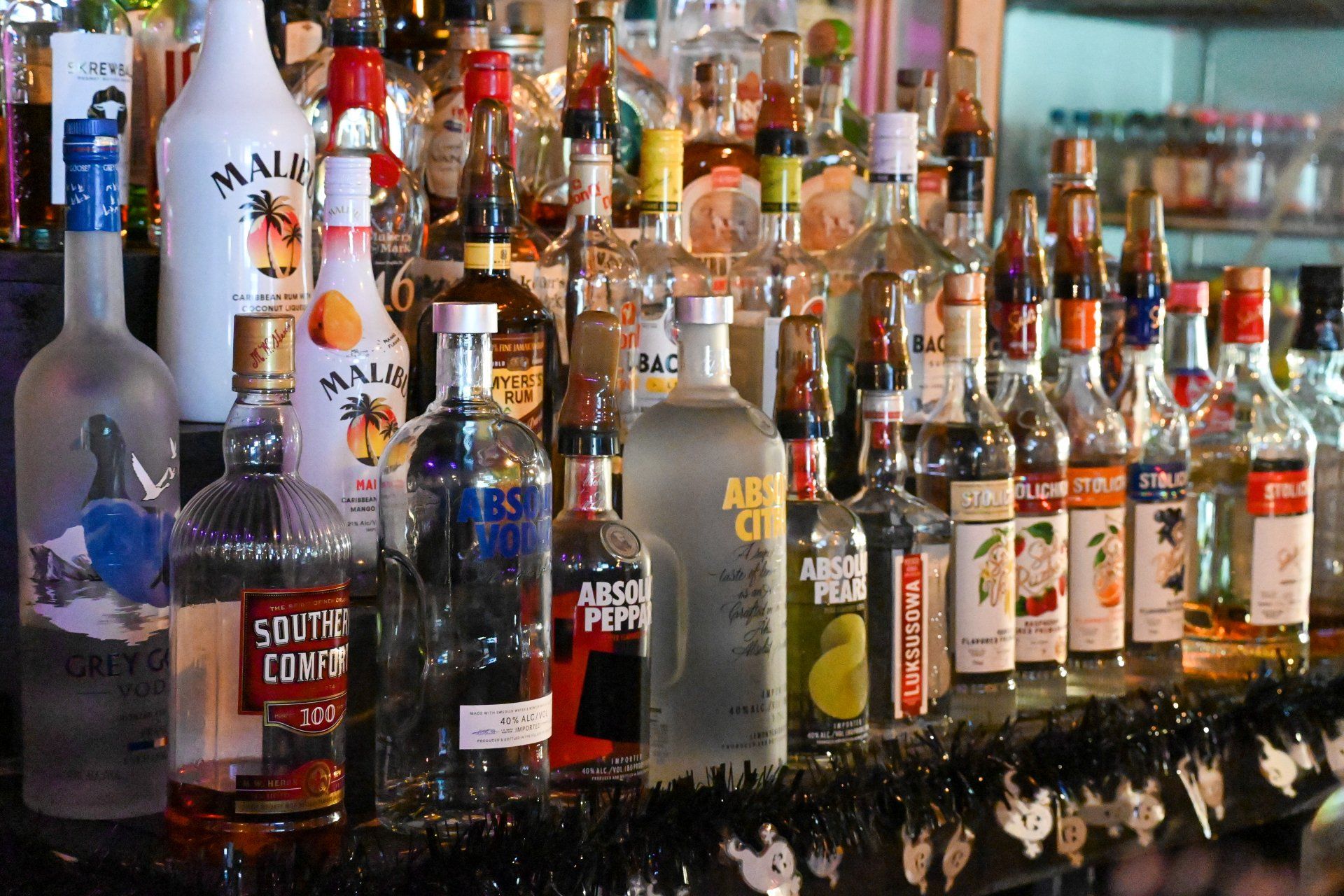 A bottle of absolut vodka sits on a bar