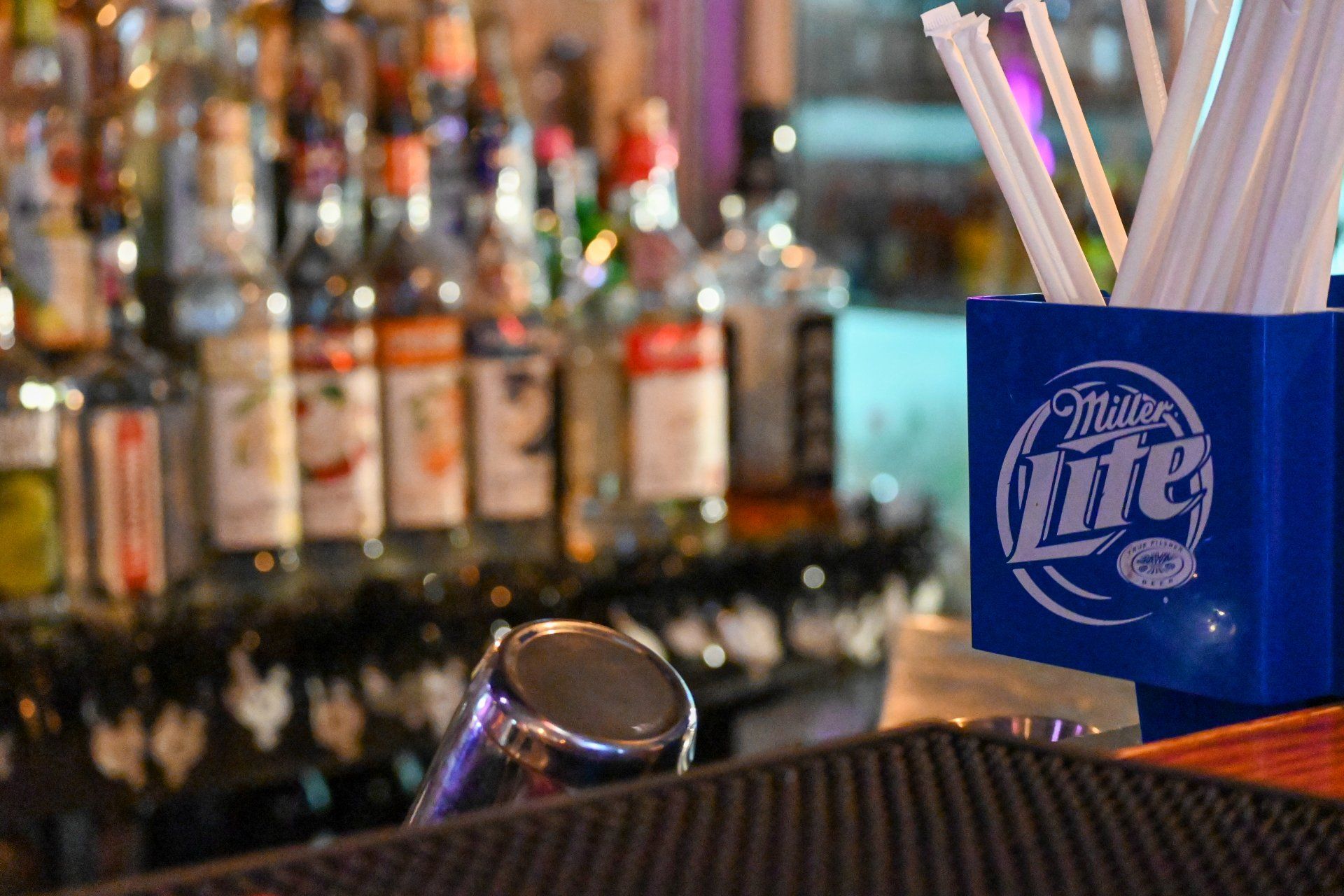 A bar with a miller lite container and straws on it