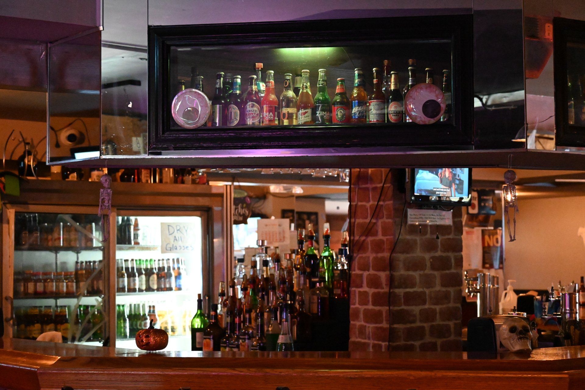 A bar with a lot of bottles of alcohol on the counter.