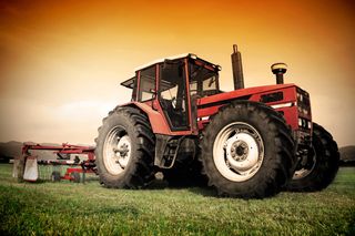 Red Tractor raking a field - farm insurance