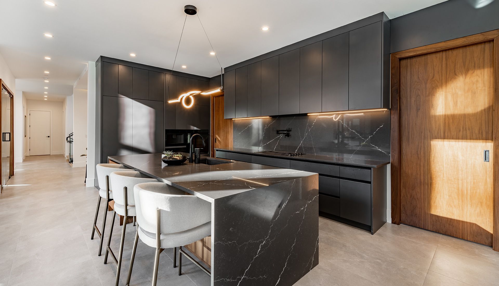 Modern kitchen with a dark gray island and cabinets, and light gray tile floor.