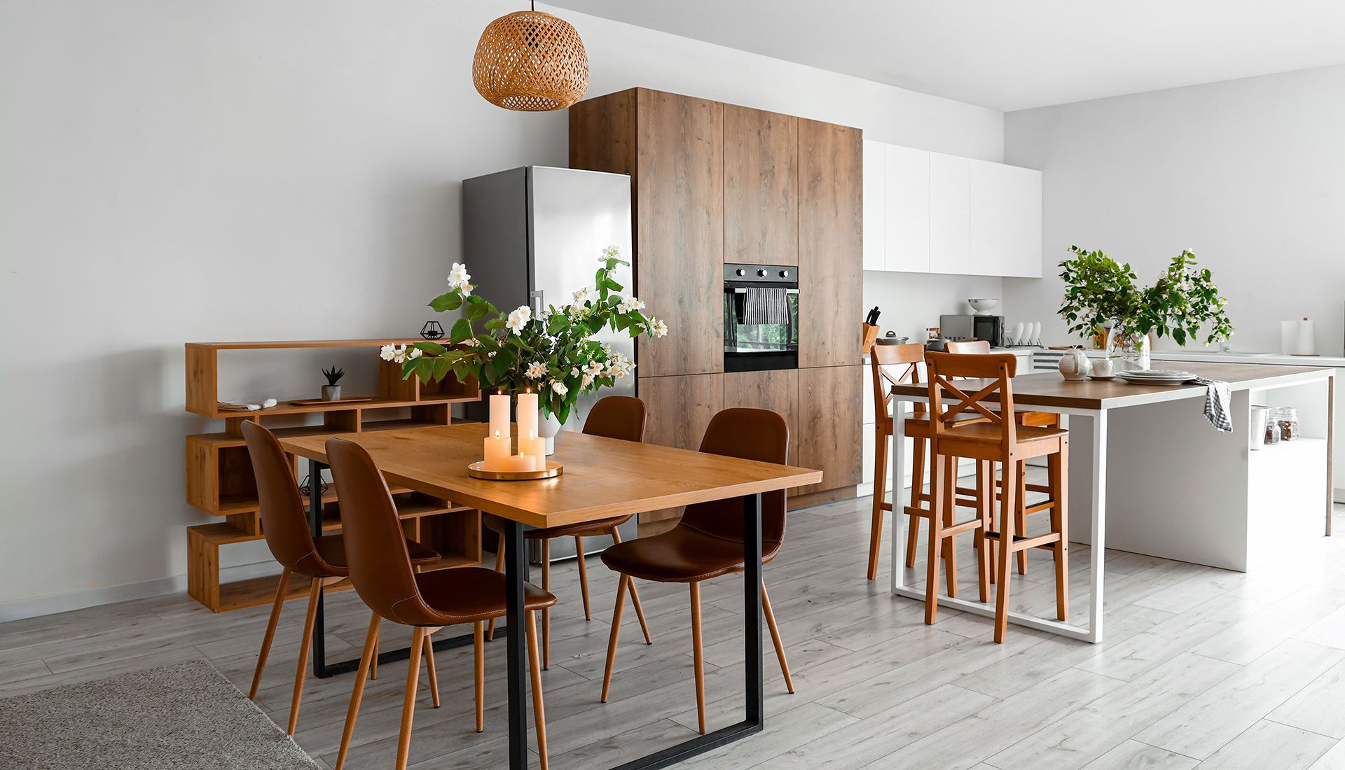 Modern kitchen and dining area with wooden furniture, white walls, and a large island.