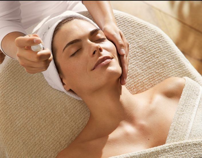 Eine Frau mit einem Handtuch auf dem Kopf bekommt eine Massage