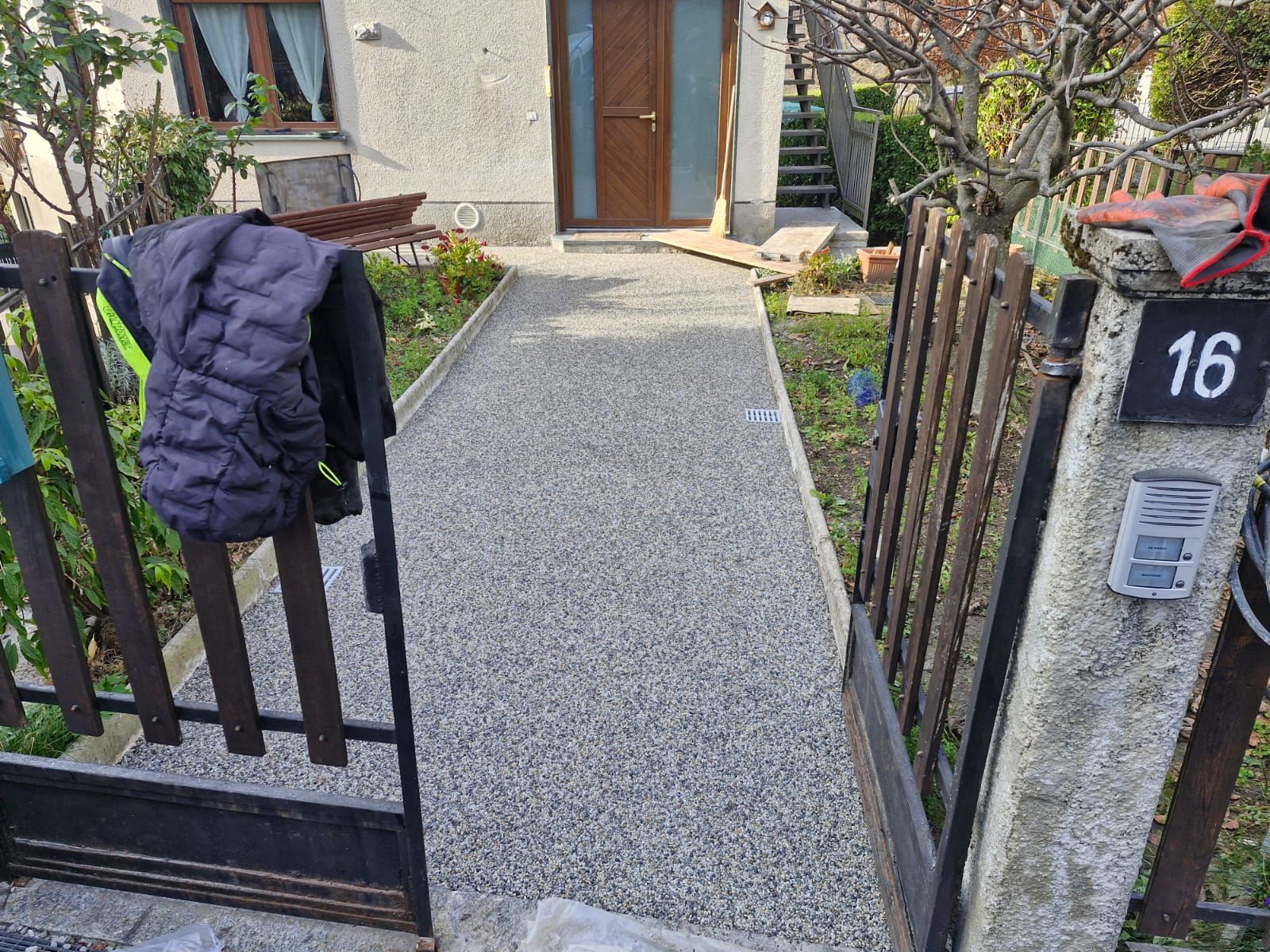 Piscina color turchese e trasparente circondata da rocce, vegetazione e una terrazza in legno sotto un cielo azzurro.